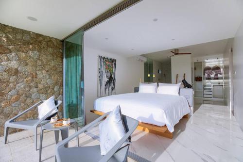 苏梅岛So Paradise Villa 4 bedrooms的一间卧室设有一张大床和石墙