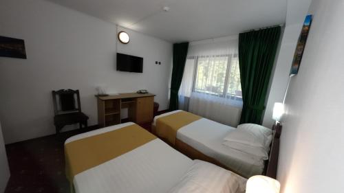 斯兰默多瓦都布鲁酒店的酒店客房配有两张床和一张书桌