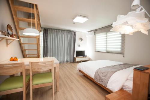 济州市Jeju Aria Pension的一间卧室配有一张床、一张桌子和一张桌子