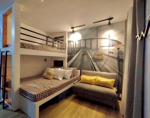 塔里萨伊Antara-QueenBed-Balcony-HotShower-WorkCoffee Station-FullKitchen的客厅配有双层床和沙发。