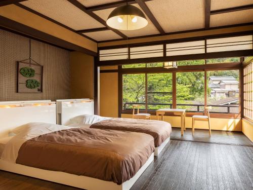 三朝町Yukai Resort Premium Saiki Bekkan的一间卧室设有两张床和大窗户