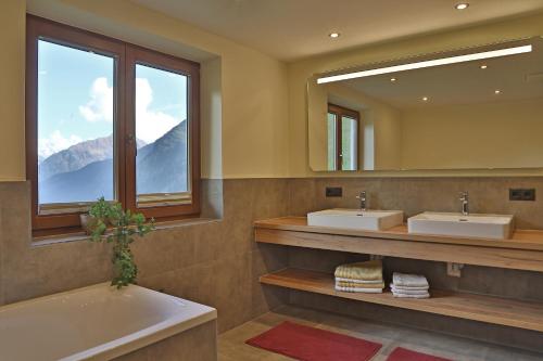 图克斯Himmenhof的浴室设有2个水槽、浴缸和镜子