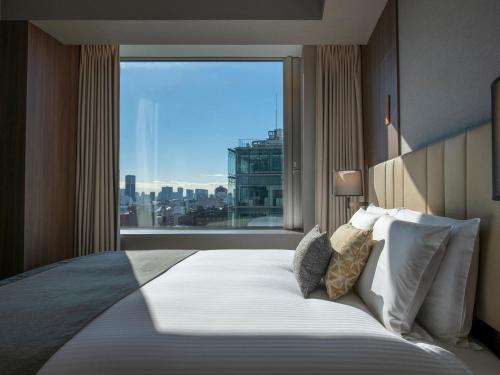 东京Mitsui Garden Hotel Roppongi Tokyo Premier的一间卧室设有一张大床和大窗户