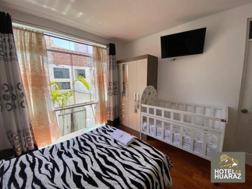 塔克纳HOTEL HUARAZ的一间卧室设有斑马图案床和窗户