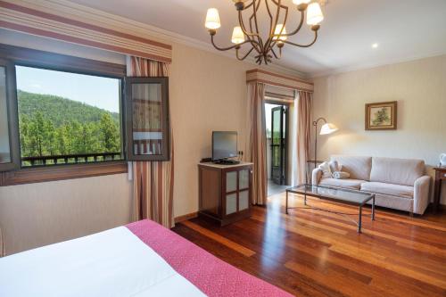 比拉夫洛尔比利亚尔瓦Spa酒店的客房设有床、沙发和窗户。