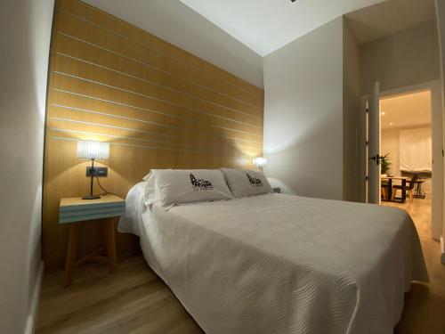 安度亚尔La Posada de San Miguel的卧室配有一张白色大床和木墙