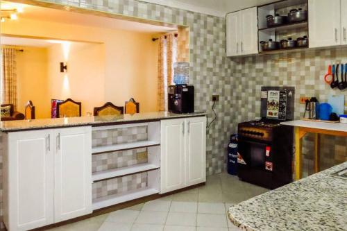 纳纽基Taliah Homestays的厨房配有白色橱柜和台面