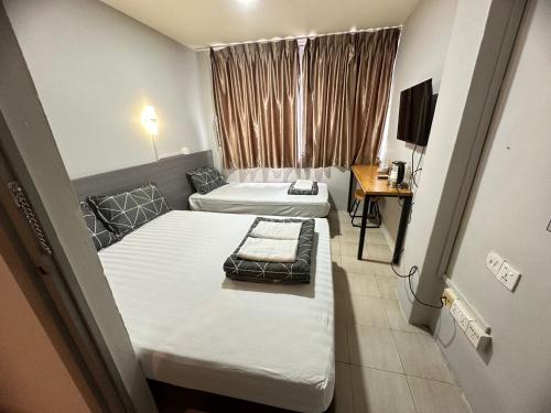 新加坡Haising Hotel的小房间设有两张床和电视