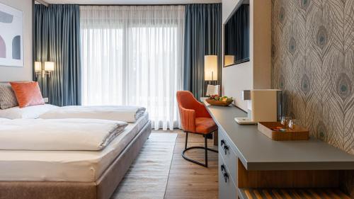 菲拉赫KULA Comfort Rooms的酒店客房配有两张床和一张书桌