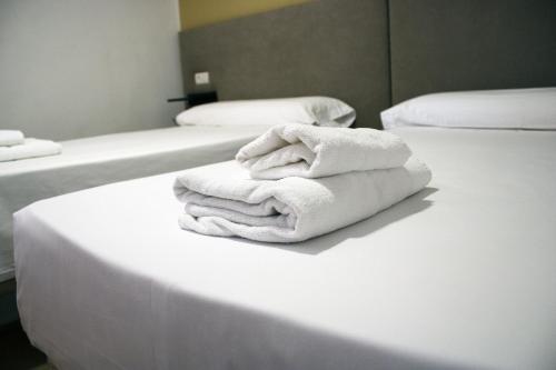 巴尔德佩尼亚斯Hostal Valdepeñas by Bossh Hotels的床上的一大堆毛巾
