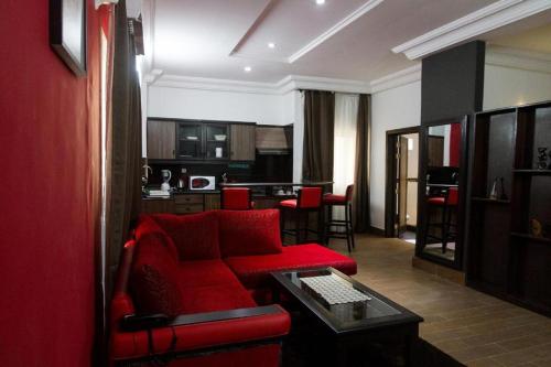 科托努Mosaly Residence Caboma的客厅配有红色的沙发和桌子