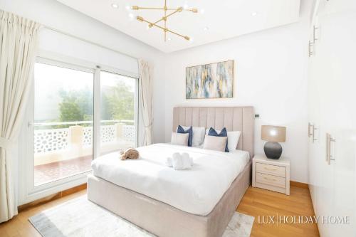 迪拜LUX The Meadows 5 Bed Villa的一间卧室设有一张大床和一个大窗户