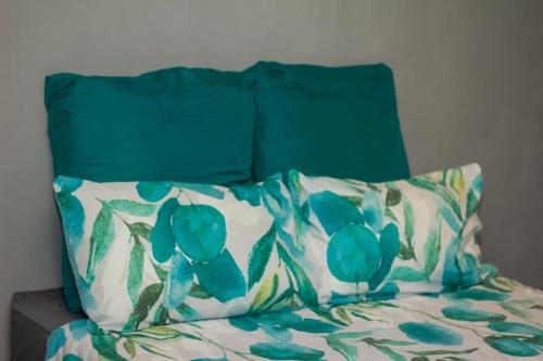 纽卡斯尔Arecavilla guesthouse的一张带绿色床头板和枕头的床