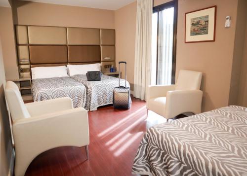 本讷图萨贝内图瑟酒店的酒店客房,配有两张床和两把椅子
