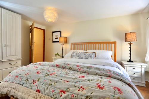 克里克豪厄尔Caboodles Cottage的一间卧室配有一张大床和两盏灯。