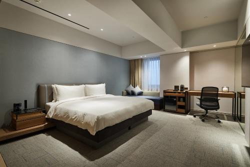 台北柯达大饭店 台北南京的一间卧室配有一张床、一张桌子和一把椅子