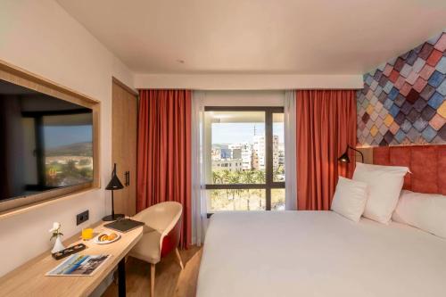 非斯Barceló Fès Medina的配有一张床、一张书桌和一扇窗户的酒店客房