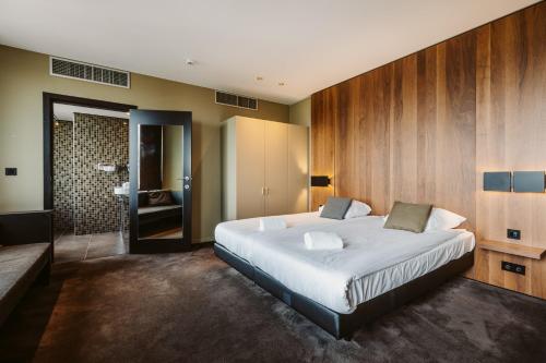 圣尼古拉赛维尔酒店的一间带大床的卧室和一间浴室