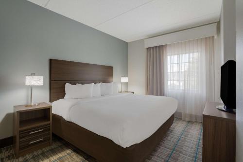 威尔明顿威尔明顿曼斯戴套房酒店的酒店客房设有一张大床和一台电视。
