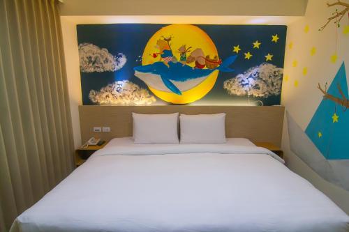 高雄秝芯旅店六合馆的卧室配有一张床,墙上挂有绘画作品