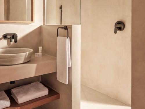 卡拉隆加Mondrian Ibiza的浴室配有盥洗盆和带毛巾的台面。