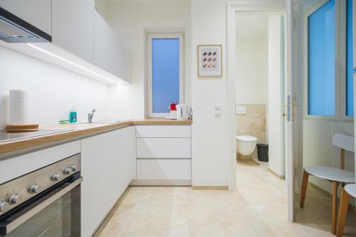 维也纳Brand Cozy Apartment的白色的厨房设有水槽和卫生间