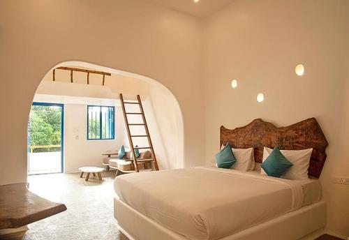 蓬蒂切里Conch Resort Luxury Private Pool Suites的卧室配有一张床,房间内设有梯子