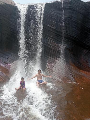 Ban Non Sungรี่สอตน้ำตกถ้ำพระ的两个男人坐在瀑布旁的水里