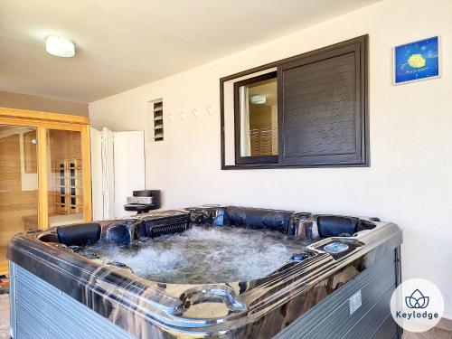 勒唐蓬Villa Marie France - avec jacuzzi et sauna - Plaine des Cafres的客房内的大浴缸装满水