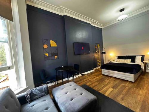 伦敦Stylish studio for 3 near Regent’s Park n3的客厅配有床和沙发