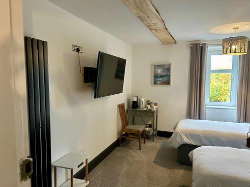 LochalineLochaline Hotel的酒店客房设有两张床和电视。