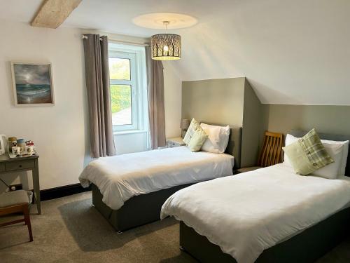 LochalineLochaline Hotel的酒店客房设有两张床和吊灯。