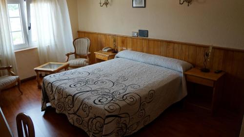 塞埃拉里酒店的一间卧室配有一张床和一把椅子
