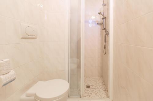 里米尼格罗布斯酒店的白色的浴室设有淋浴和卫生间