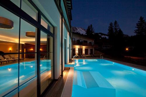 巴特欣德朗奥贝吉奥池全景酒店的一座晚上设有游泳池的房子
