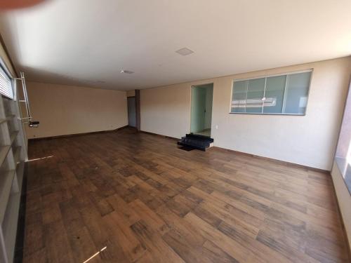 皮乌米Casa de temporada的一间铺有木地板的空房间和一间带窗户的房间