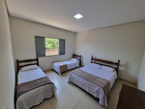 皮乌米Casa de temporada的一间卧室设有两张床和窗户。