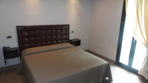 巴亚多米吉亚BNS Hotel Francisco的一间卧室配有一张带床头板的床和窗户