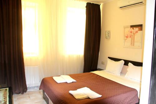 敖德萨布瑞姿酒店的一间卧室配有一张床,上面有两条毛巾