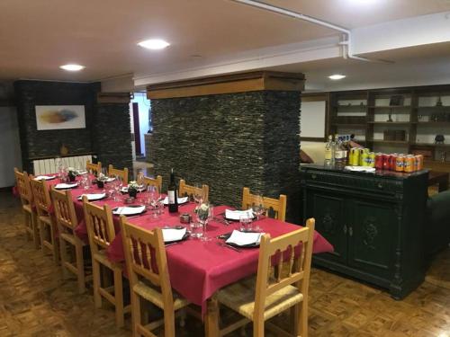 贝纳斯克Hotel Vallibierna的一间带红色桌布的餐桌的用餐室