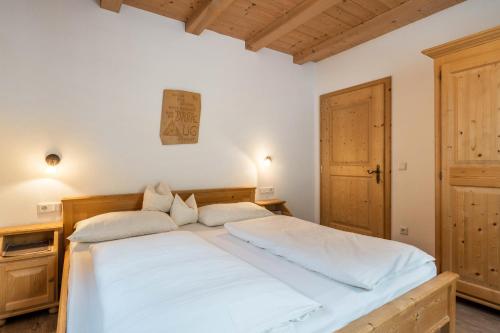 瓦尔道拉Kranebitterhof Apt Edelweiss的一间卧室配有一张带白色床单的大床