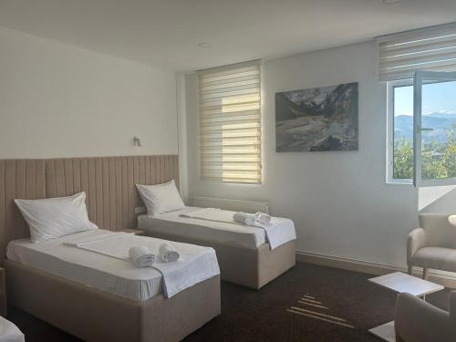 比耶洛波列Naš Dom Hotel的配有窗户的酒店客房内的两张床