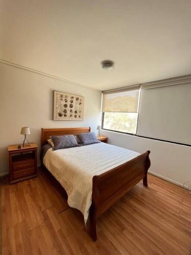 科皮亚波Exclusivo y cómodo departamento的一间卧室设有一张大床和一个窗户。