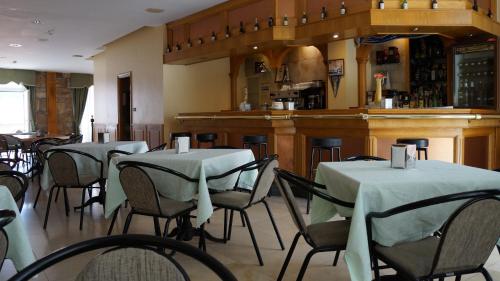 塞埃拉里酒店的一间带桌椅的餐厅和一间酒吧