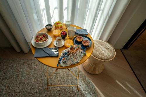 布拉加SUTRooms的一张黄色桌子,上面有食物和饮料