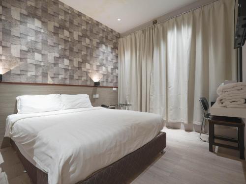 新加坡Noble Hotel Express, Check in 10PM, Check out 9AM的卧室配有一张白色大床和一张书桌