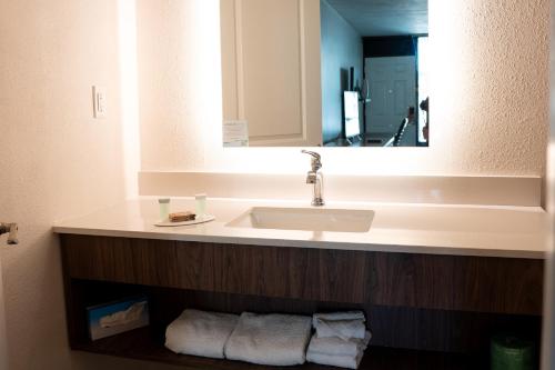 克利尔沃特Howard Johnson by Wyndham Clearwater - Dunedin的浴室配有盥洗盆、镜子和毛巾