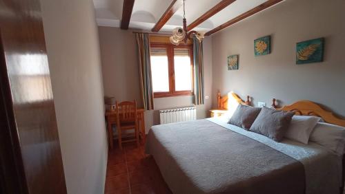 GuadalaviarCasa Rural Lahuerta Apartamentos的一间卧室设有一张床、一个窗口和一张桌子