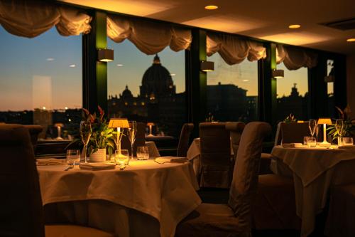 罗马亚特兰特星级酒店的一间设有两张桌子的餐厅,享有城市美景