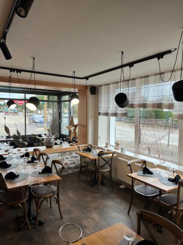 欧丹冈L Asterie的餐厅设有木桌、椅子和窗户。